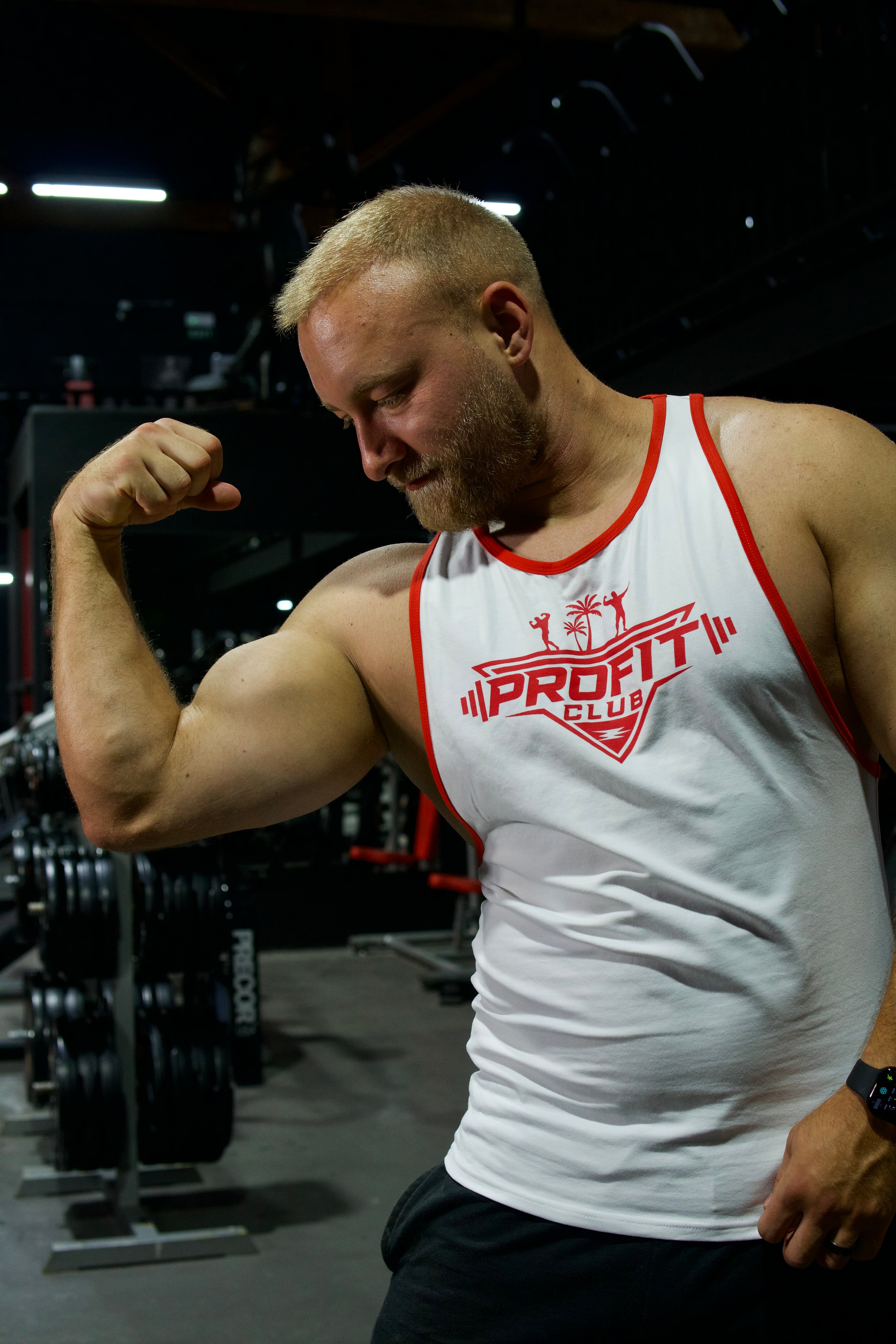Camiseta de tirantes blanca ProFit Club con logotipo rojo en el pecho y ribetes rojos, ideal para entrenar y para el día a día.