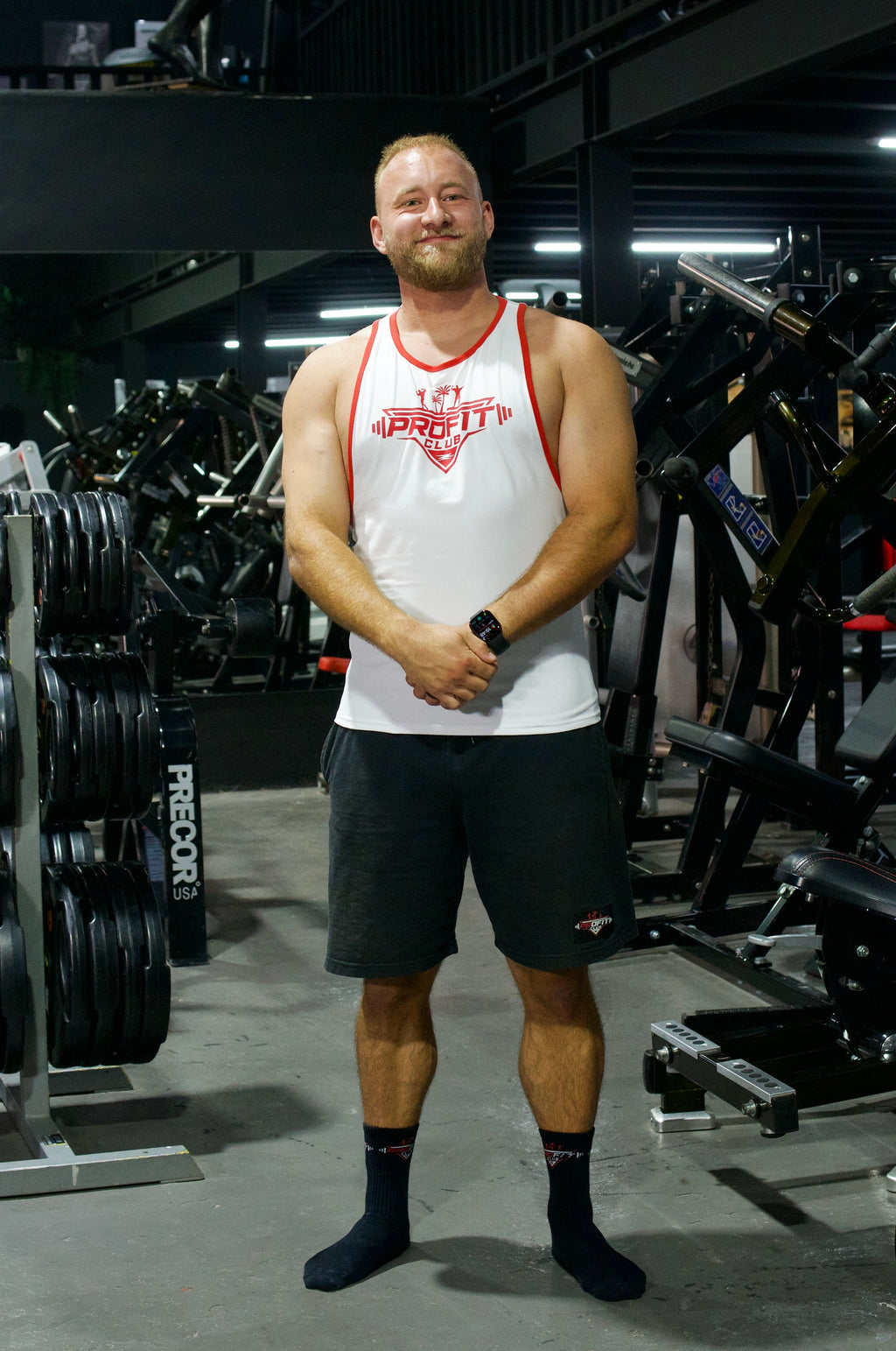 Camiseta de tirantes blanca ProFit Club con logotipo rojo en el pecho y ribetes rojos, ideal para entrenar y para el día a día.