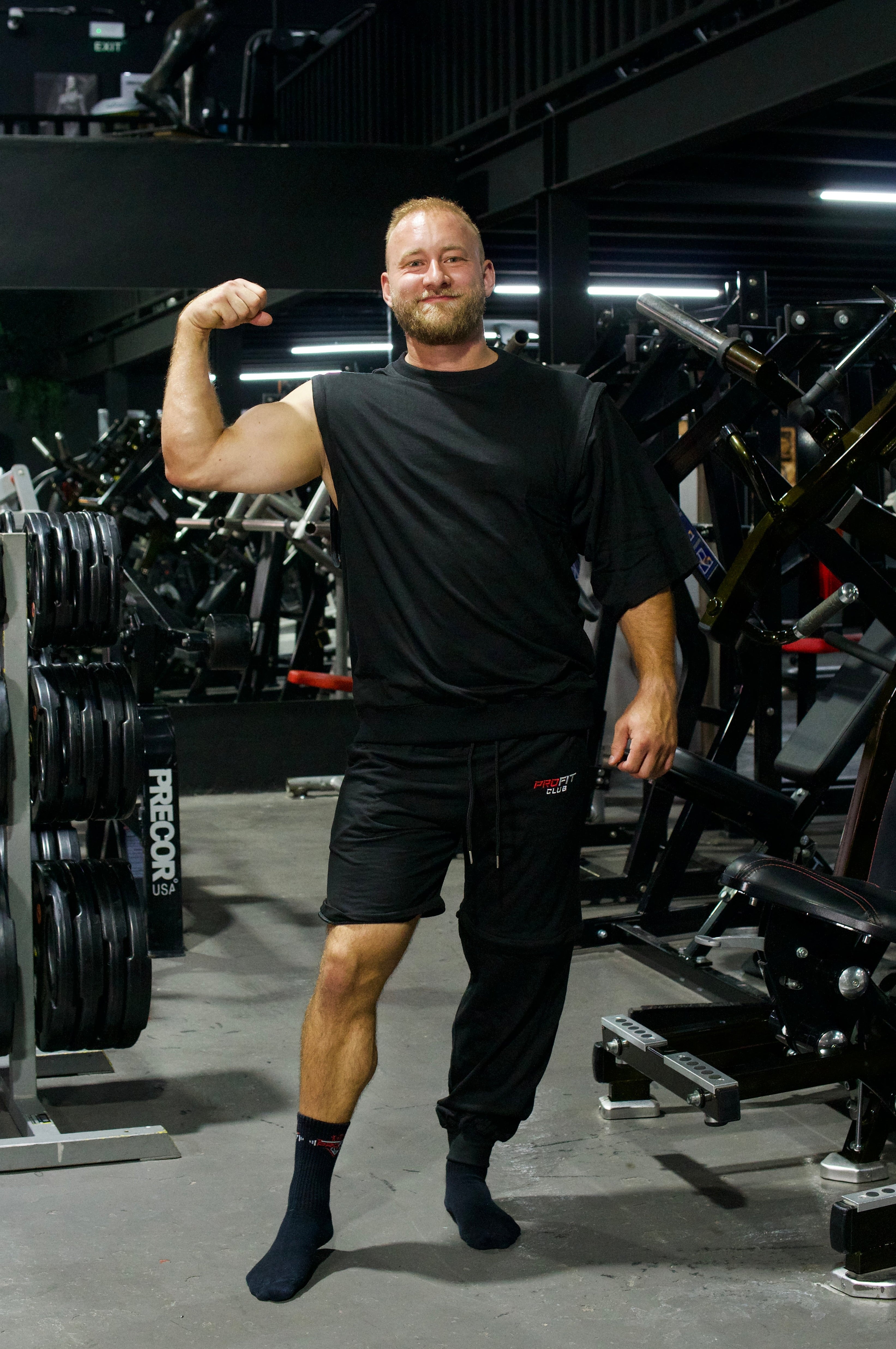 Athlet trägt ein schwarzes Zip-off-T-Shirt mit abnehmbaren Ärmeln und eine schwarze Zip-off-Hose im Oversize-Look.