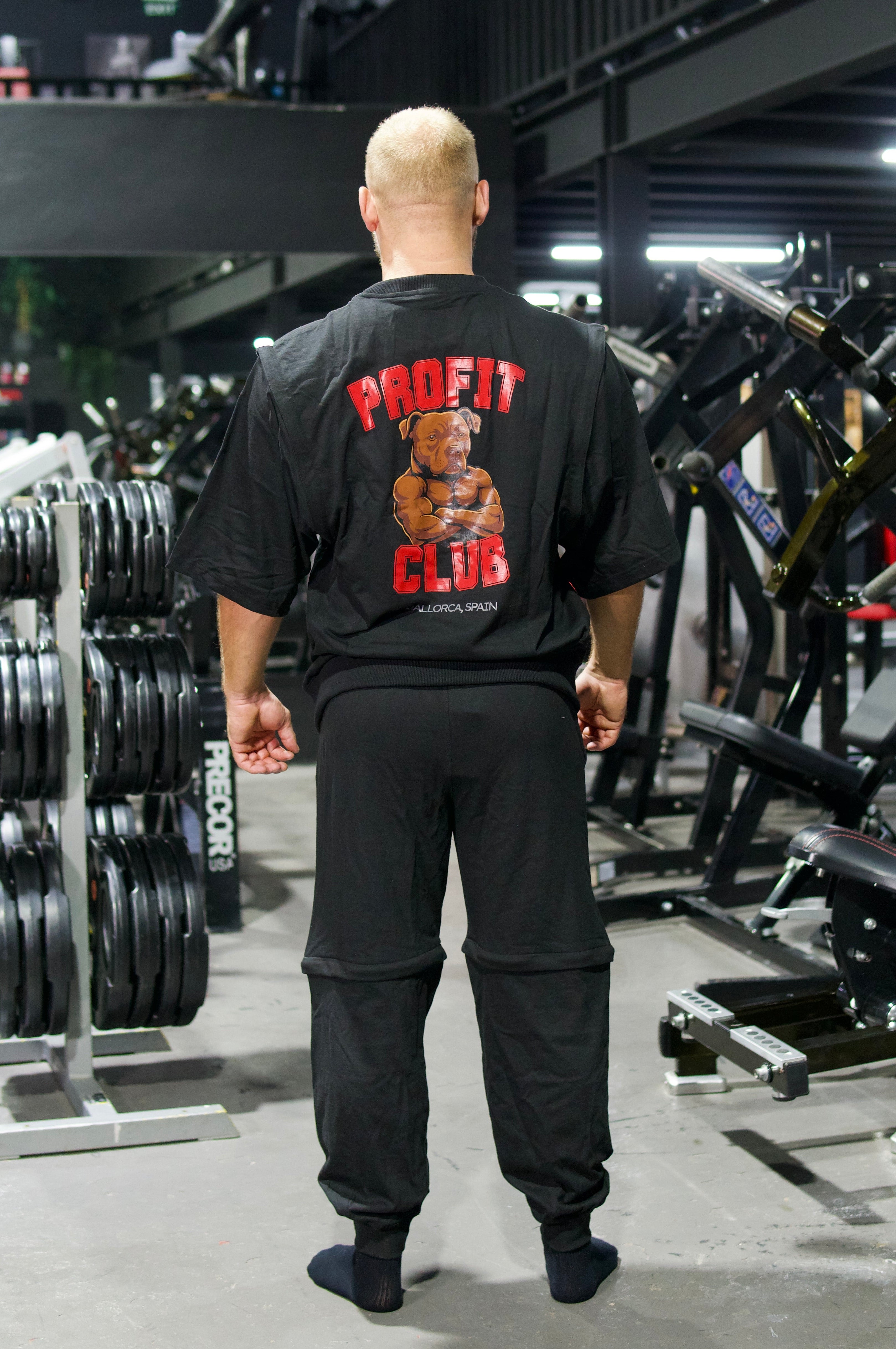 Athlet trägt ein schwarzes Zip-off-T-Shirt mit abnehmbaren Ärmeln und eine schwarze Zip-off-Hose im modernen Oversize-Look.